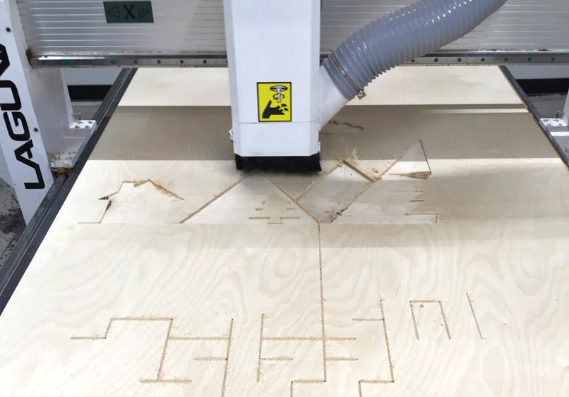CNC machine cutting out wood forms used on exhibit wall