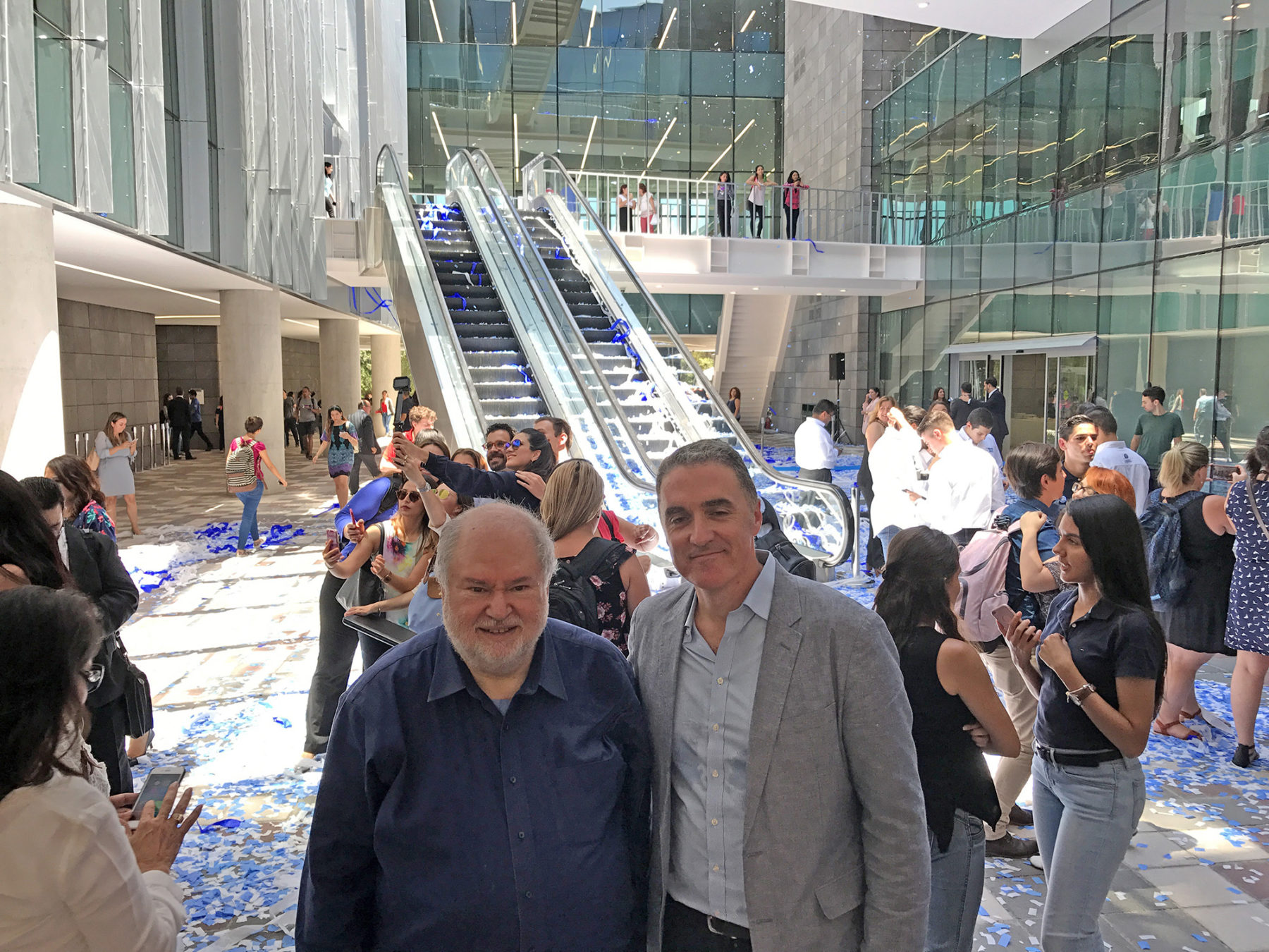 two men pose inside a building