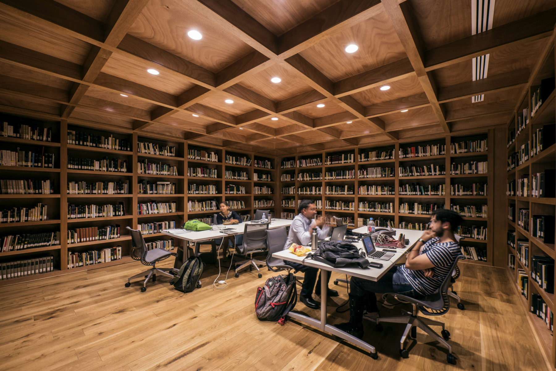 students at a table in a room lined with bookshelves