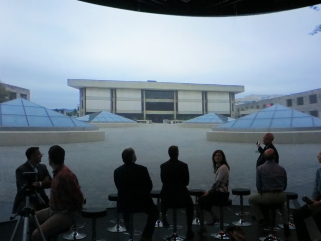 People presenting in front of large screen