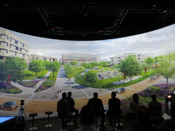 People presenting in front of large screen