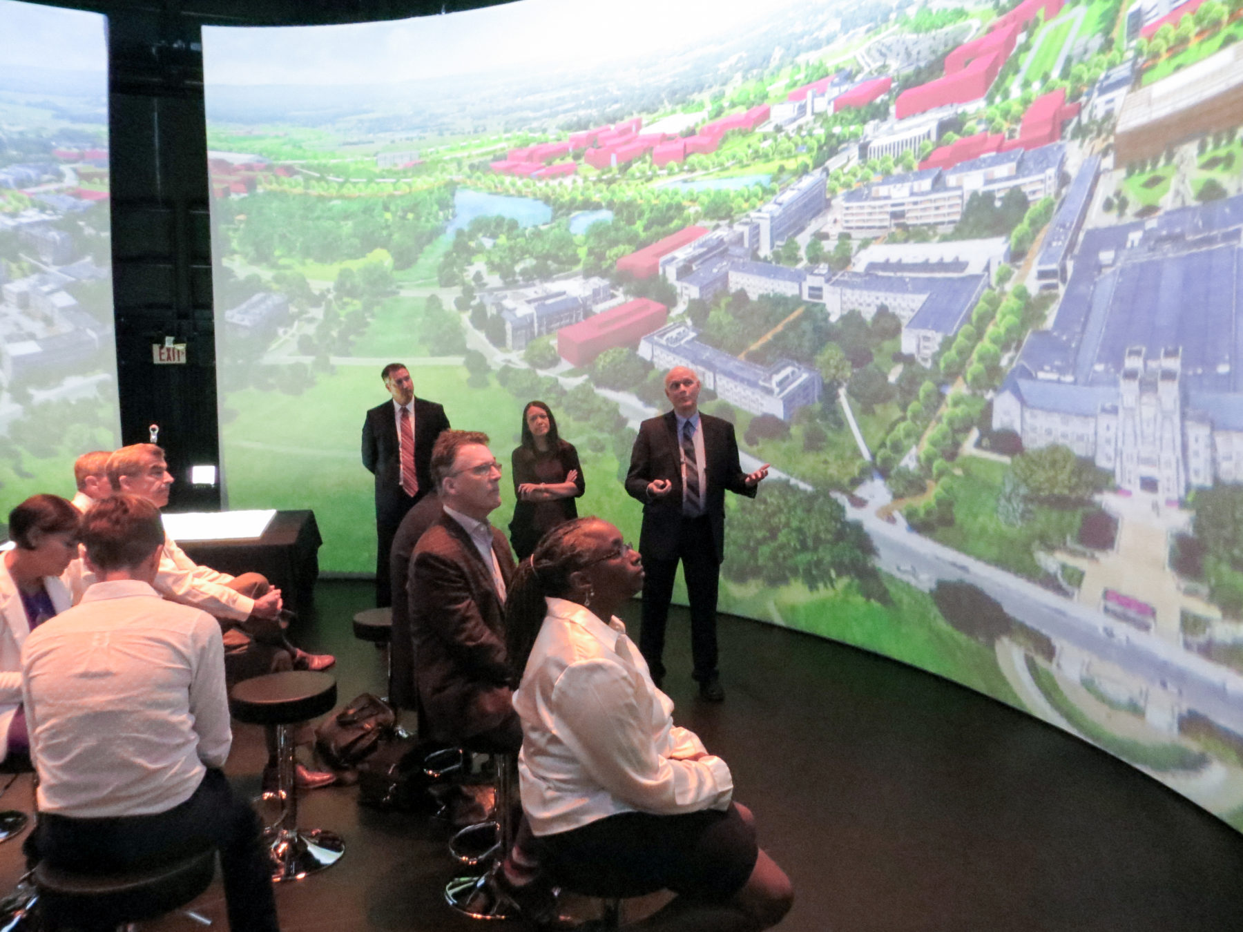 Group of designers in front of 360 wraparound presentation screen