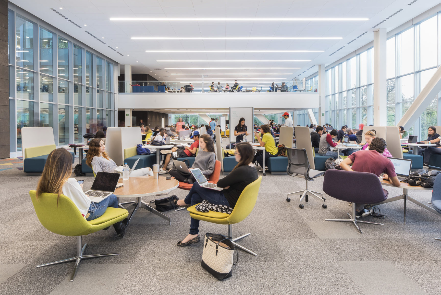 Students sitting at chairs in a common space