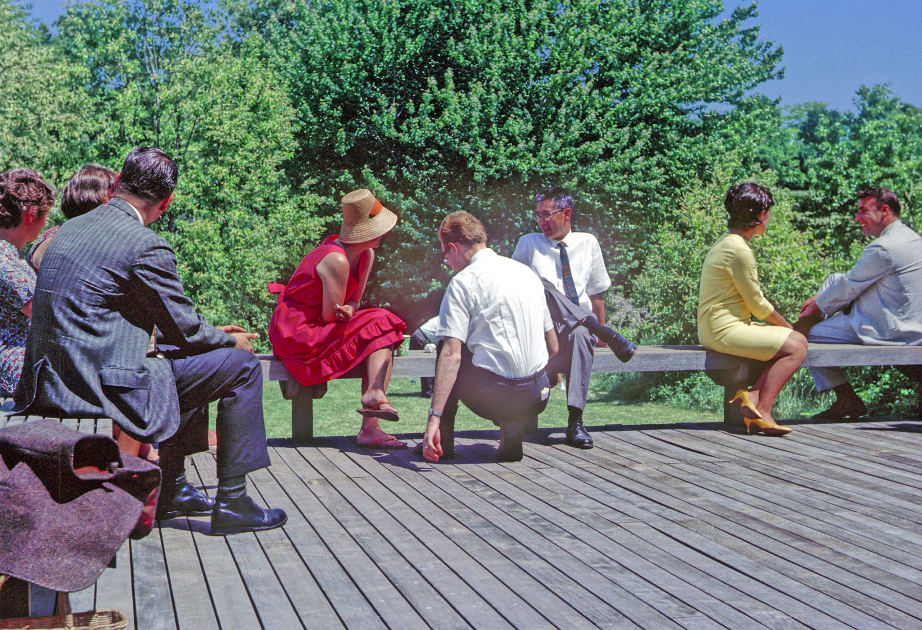 vintage photo of Hideo Sasaki sitting on deck at a party with people in brightly colored clothes