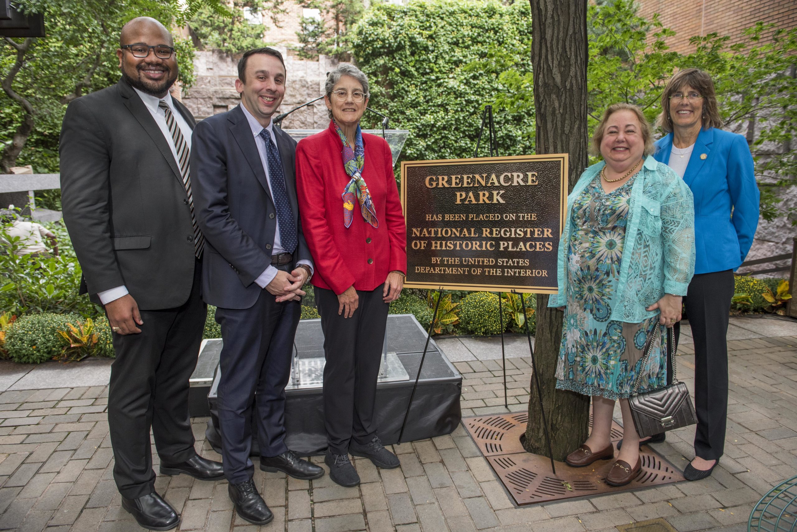 people standing by plaque