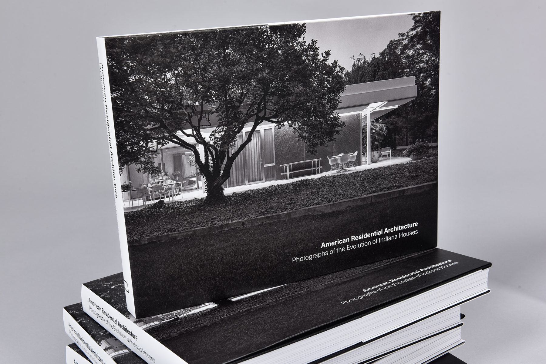 Black and white photo of stacked books with the front cover visible