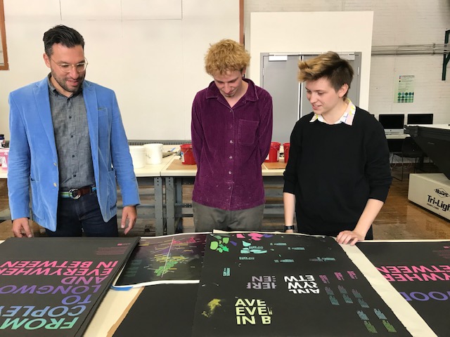 Mass Art students surveying printed work