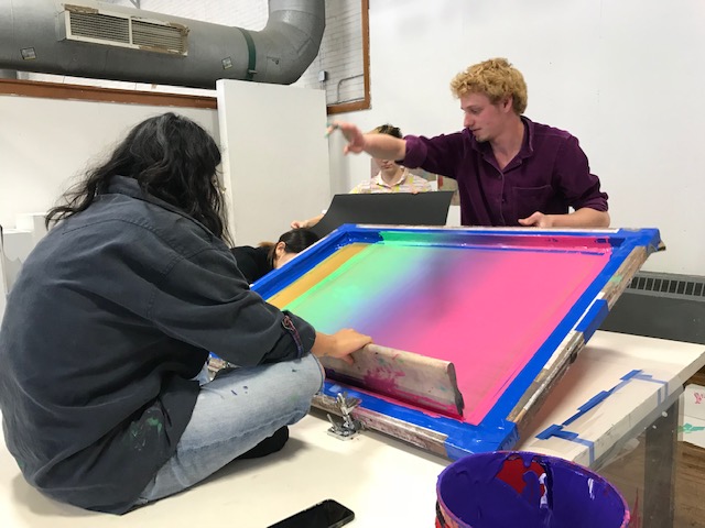 Two art students preparing a print