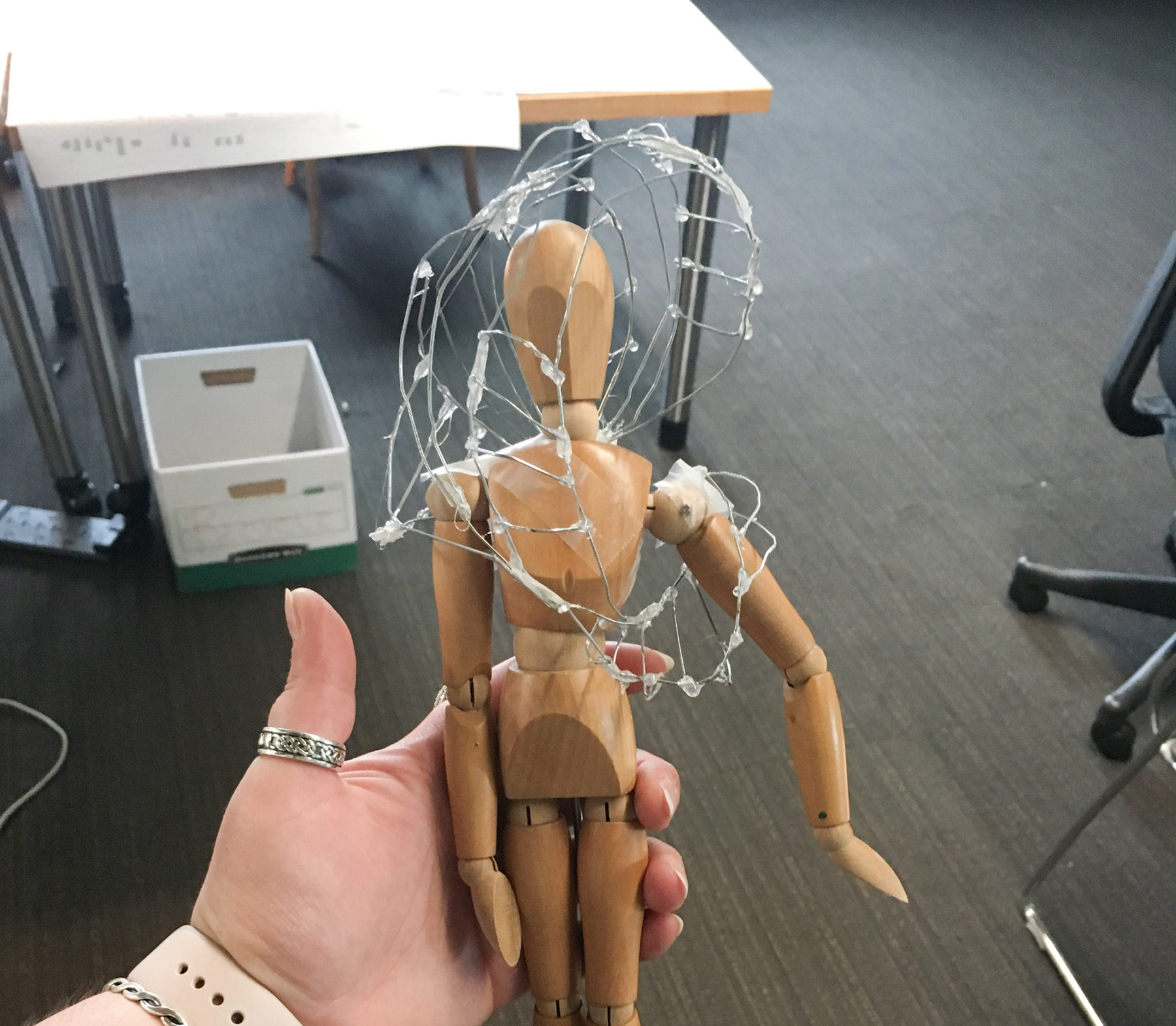 wooden mannequin with wire on it
