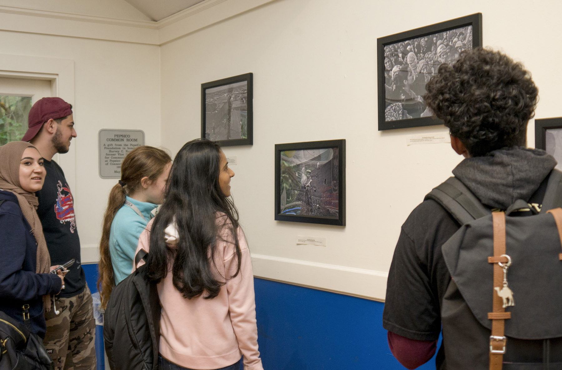 students looking at photos on a wall