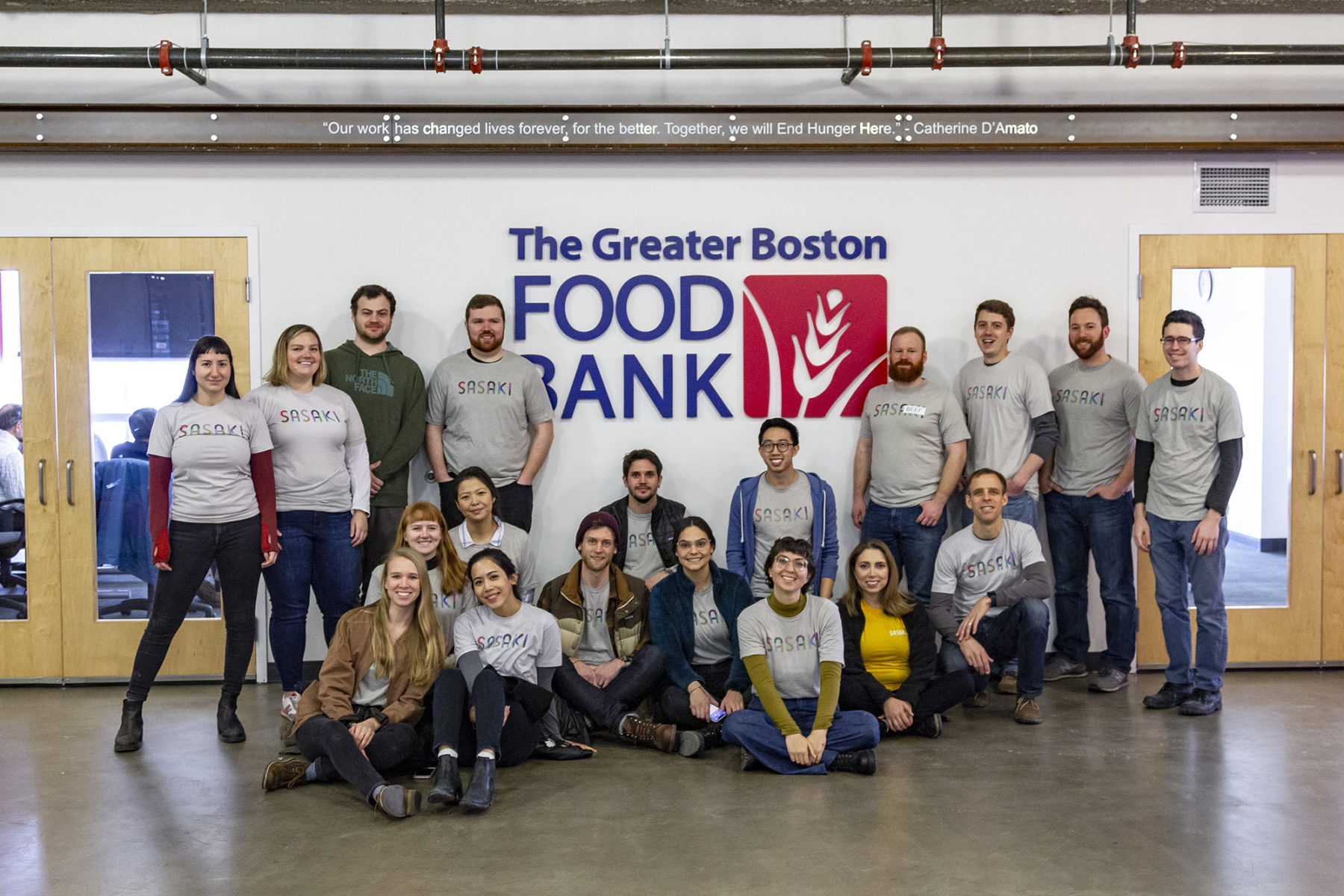 Photo of a group of Sasakians gathered around the The Greater Boston Food Bank sign at their location