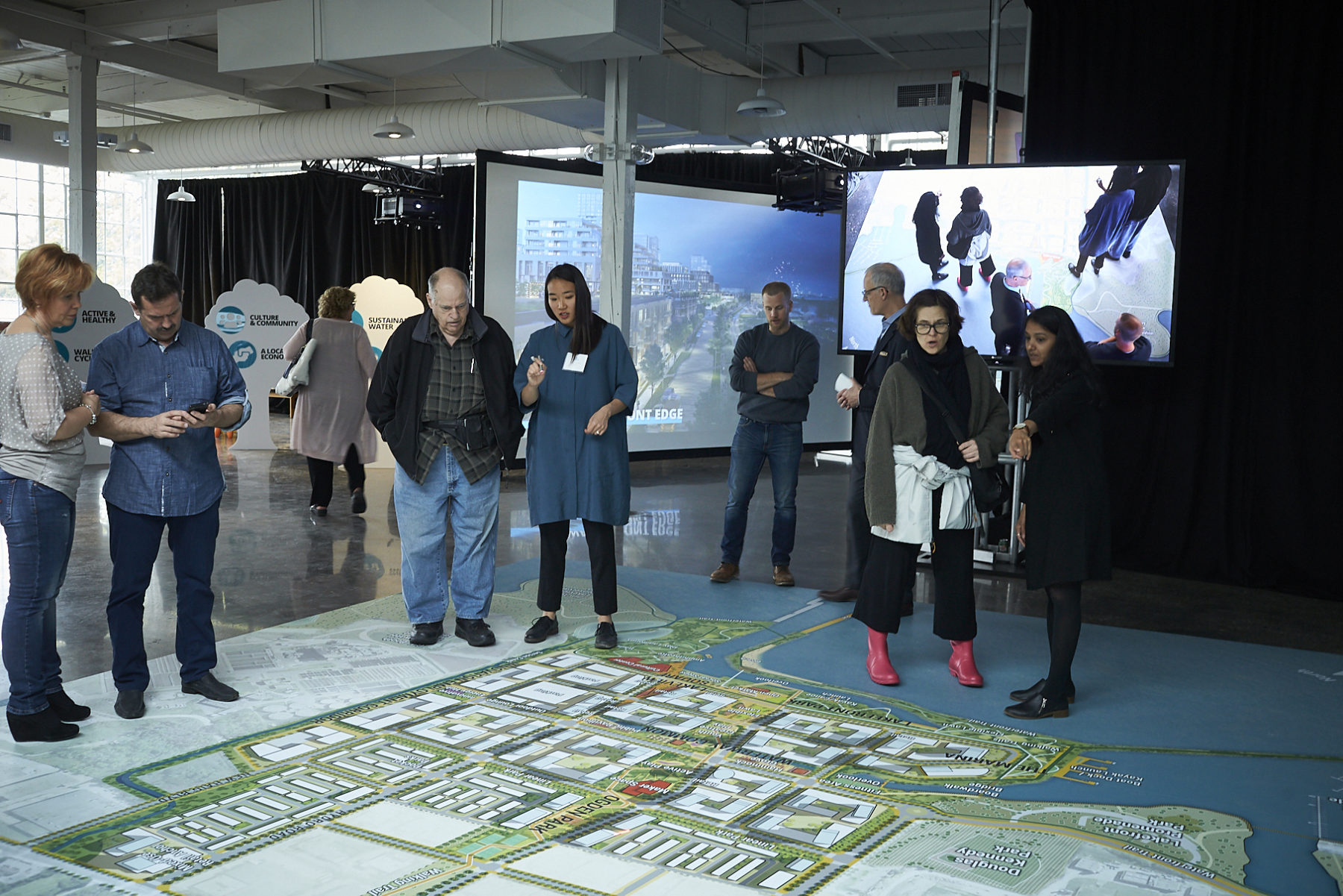 Attendees to public meeting look down at giant floor map