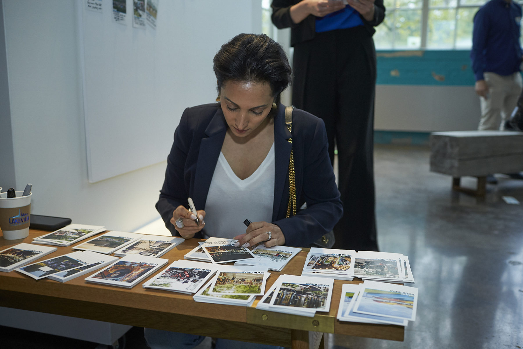 Young woman writes her comments on a printed image card at public meeting