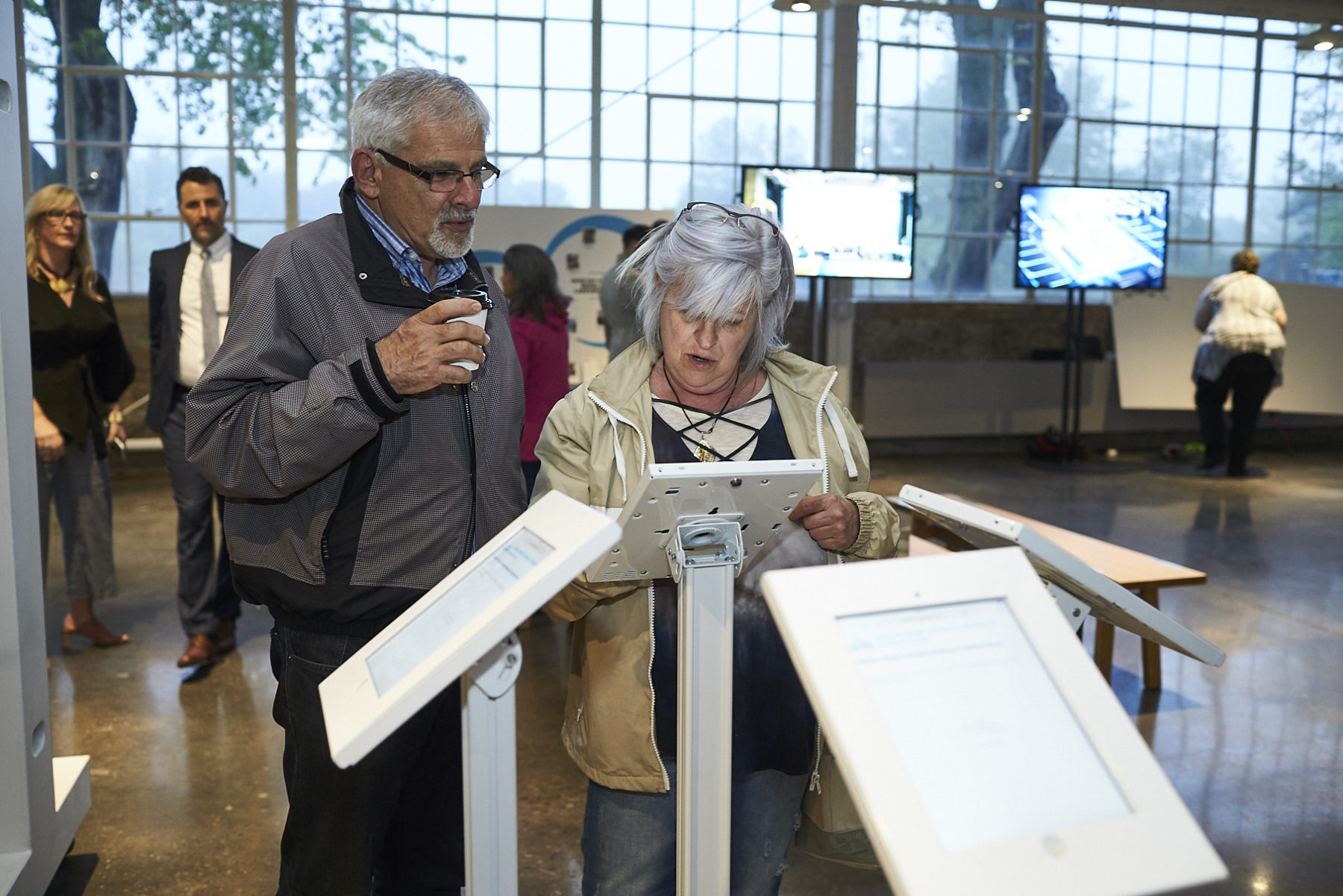 Older couple looks at placard with information about the plan