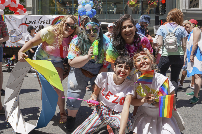 Photo of group posing at parade with bubbles