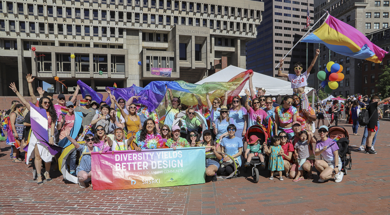 Photo of group gathered on Boston's City Hall plaza posing with banner
