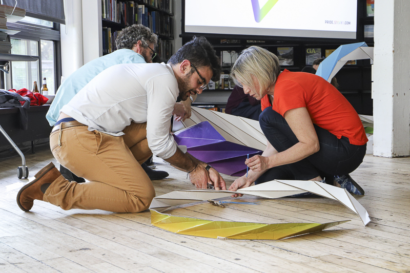 People kneeling on floor to assemble parade props