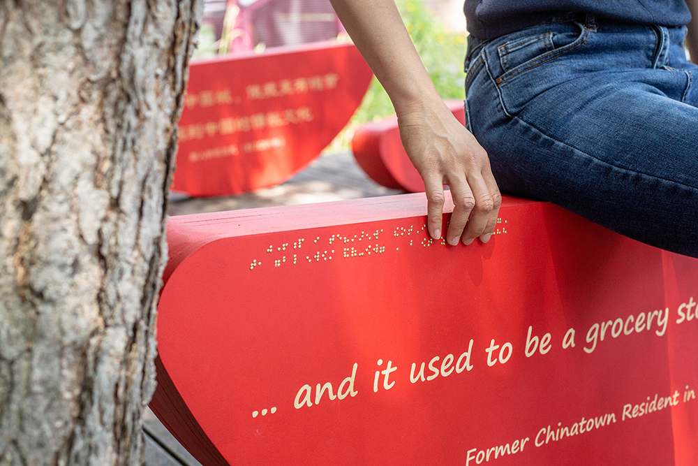 someone reading the braille text embossed on the bench