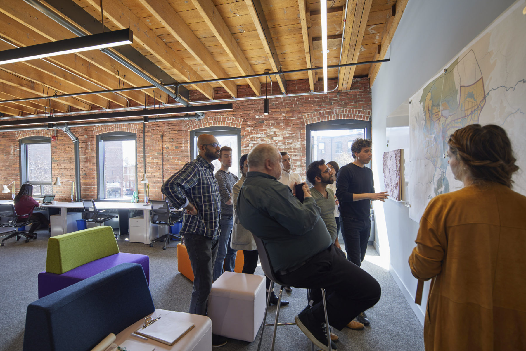 people gathered around a map on a wall