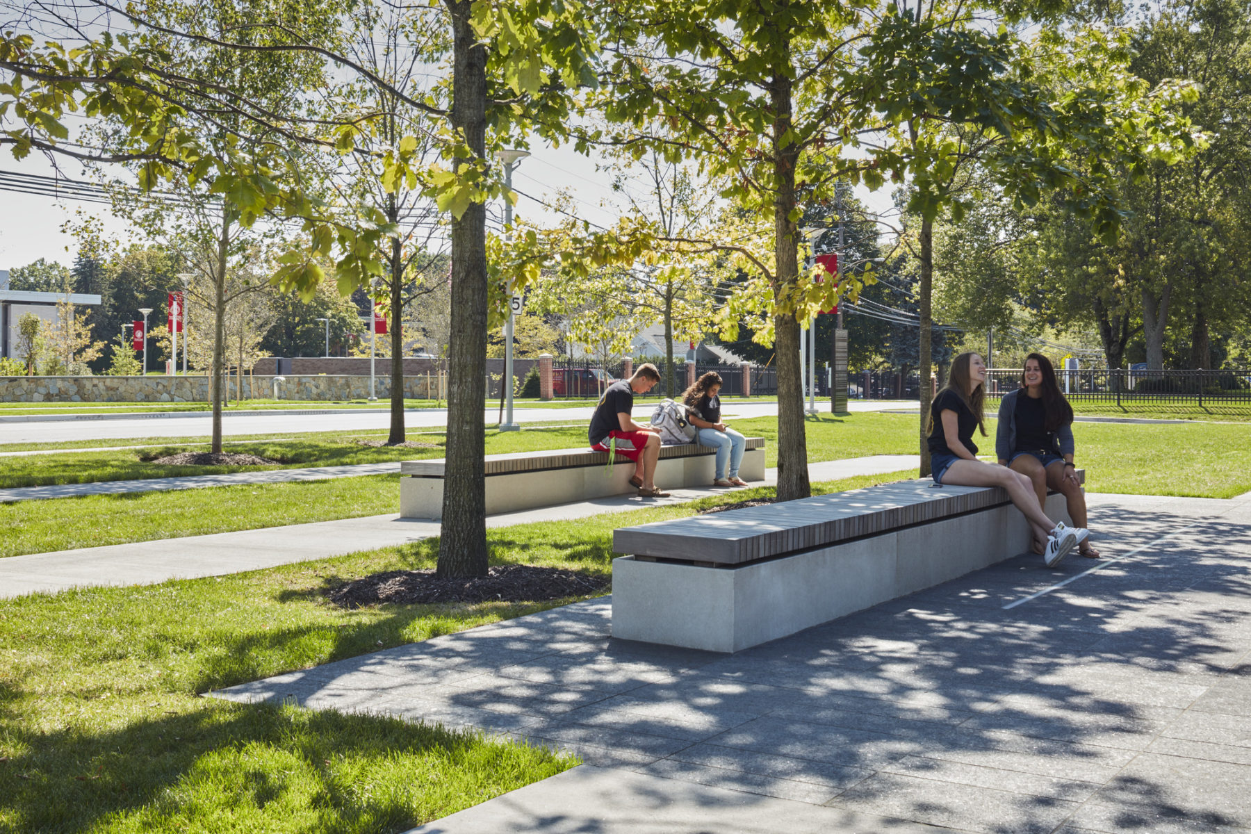 two pairs of people sit on separate benches