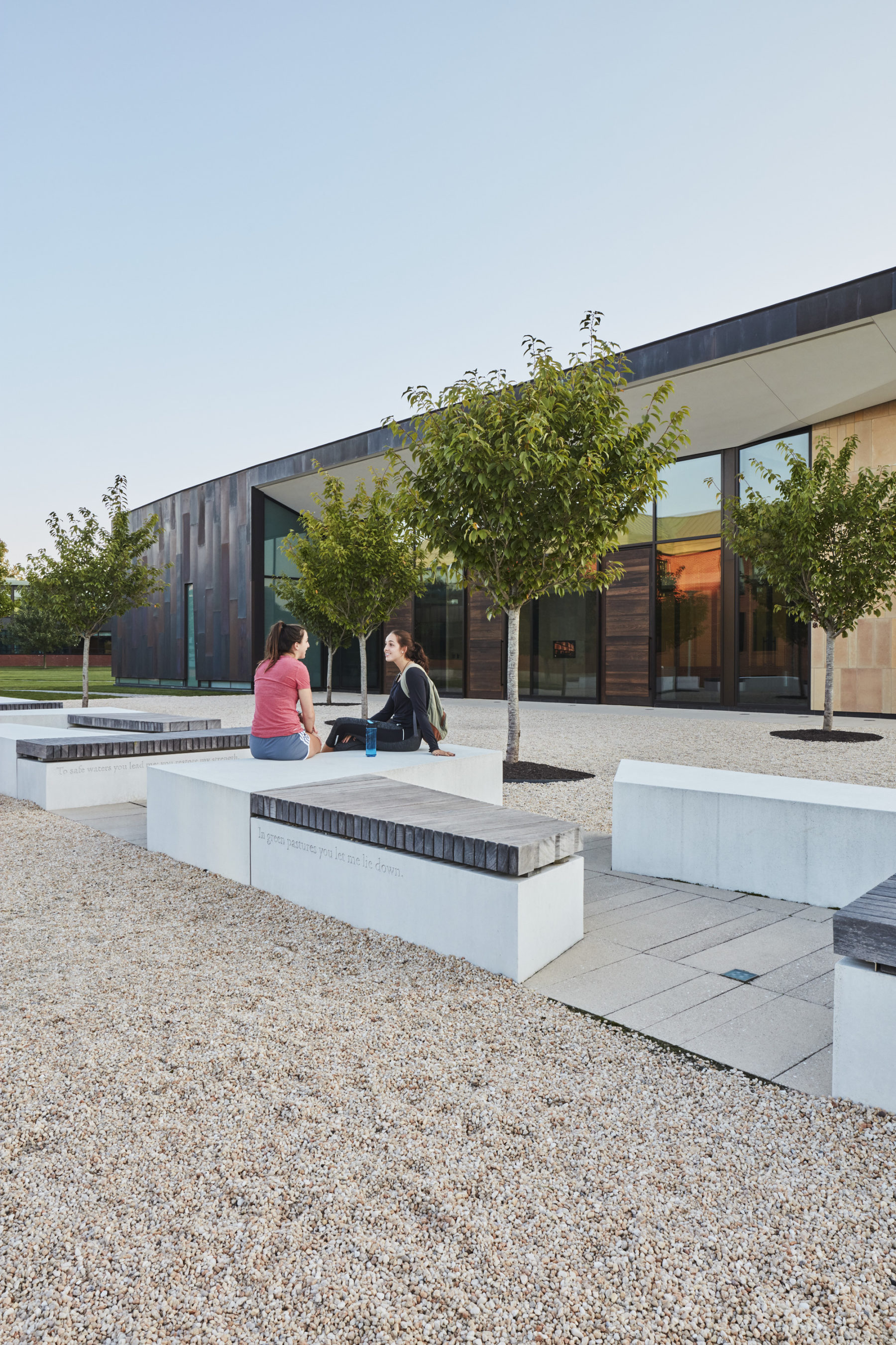 Two people sit outside on benches