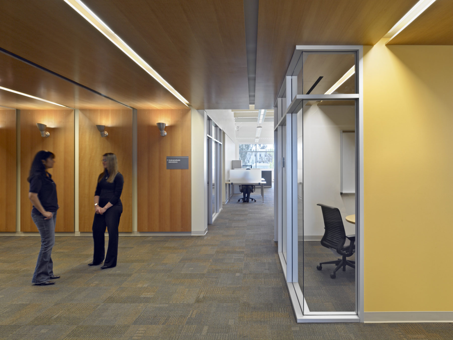 Interior photo of two women talking outside of an office