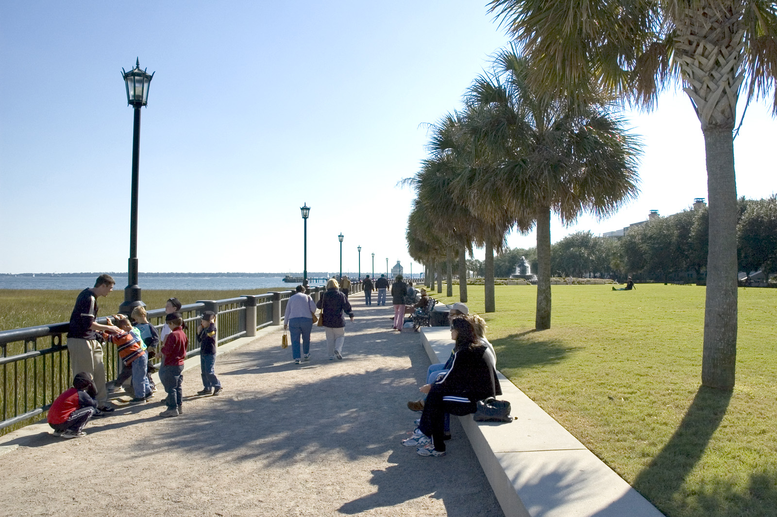 Photo of people sitting along waterfront path in park