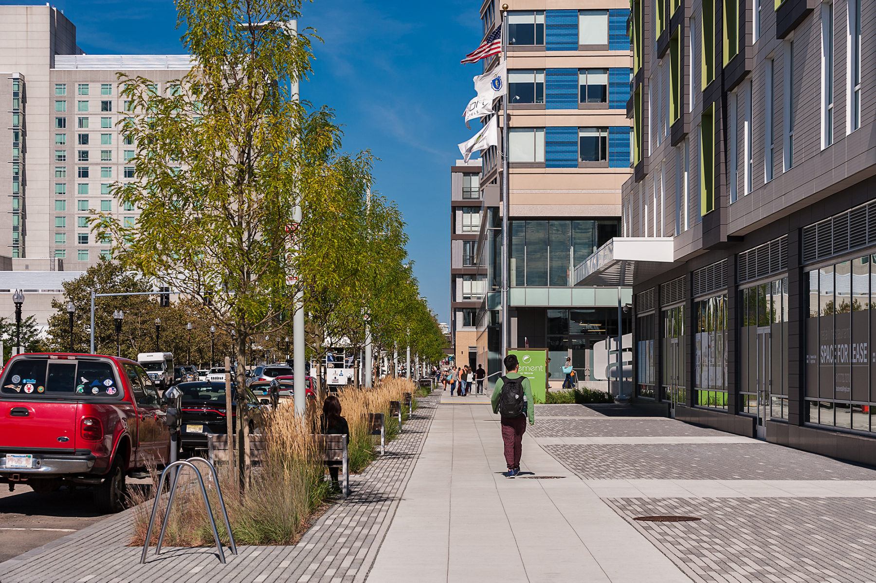 Photo of a man walking on the sidewalk in the corridor