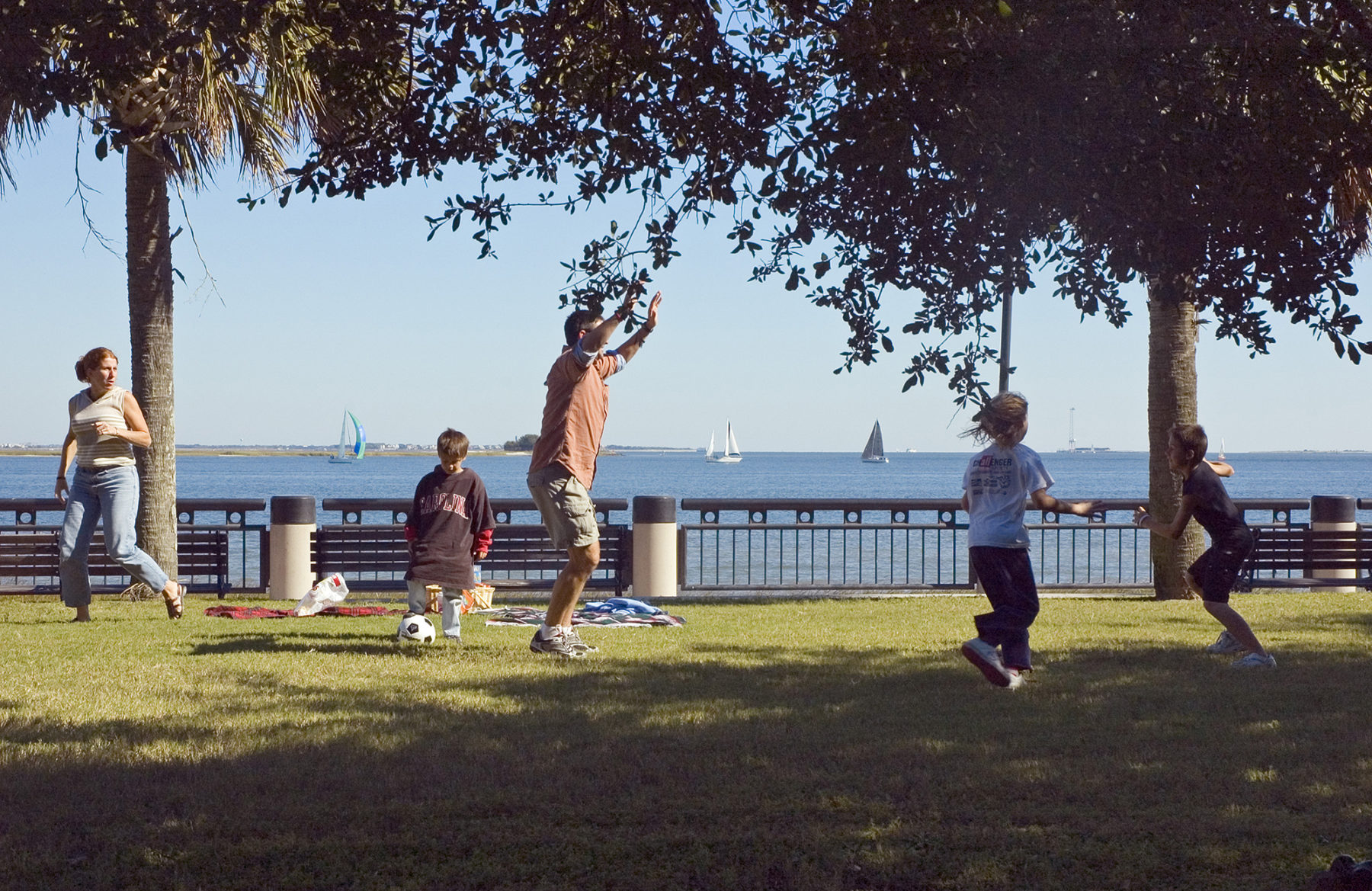 Photo of children and adults playing soccer in park