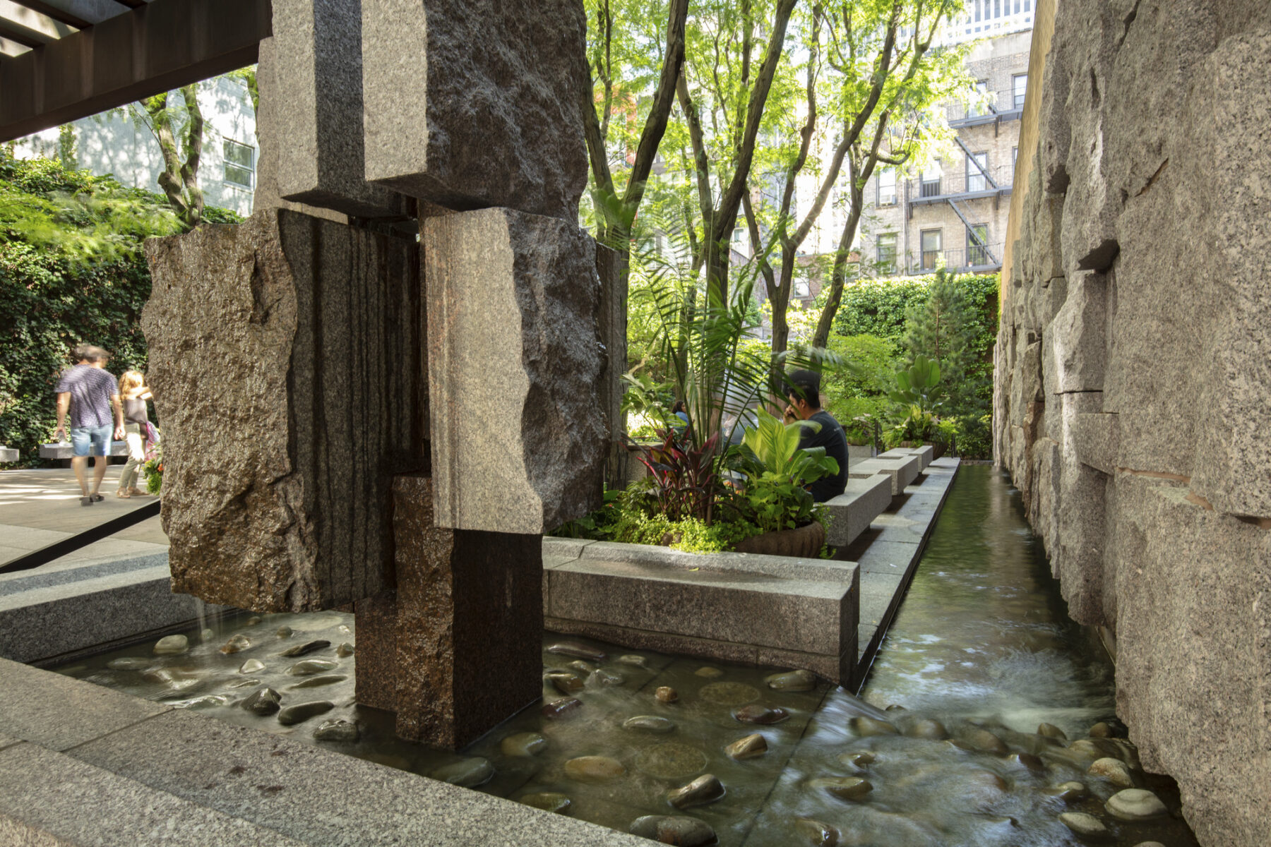 Corner view into the park showing close up detail of water and stone materials