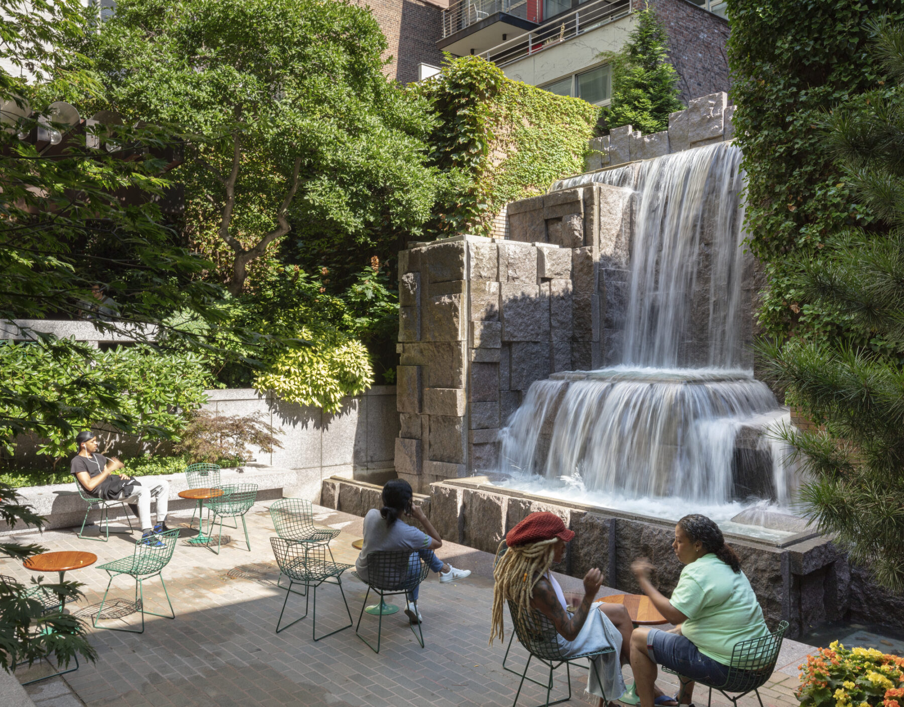 Photo of park with visitors enjoying seating beside the waterfall