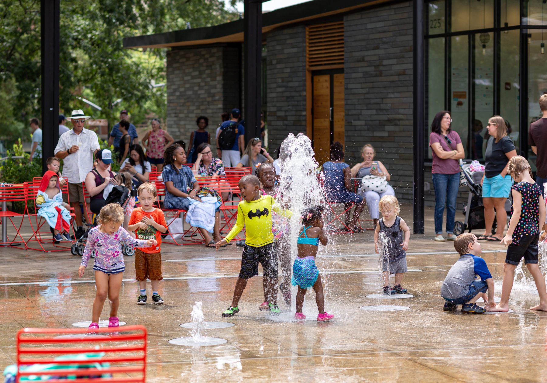 Children play under a fountain in Moore Square