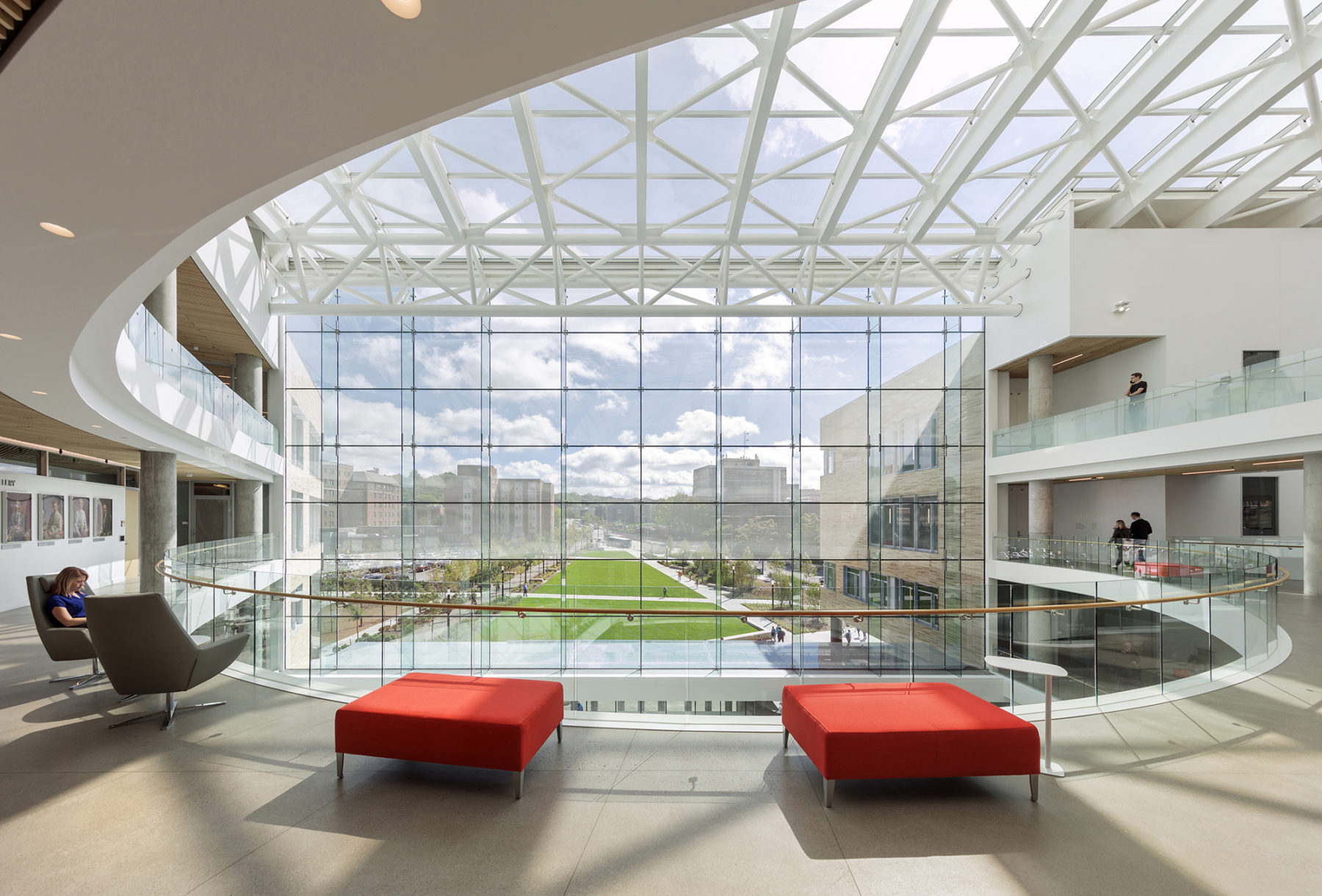 Interior view of the Tepper Quadrangle looking out towards the front lawn with two red sofas in the middle.