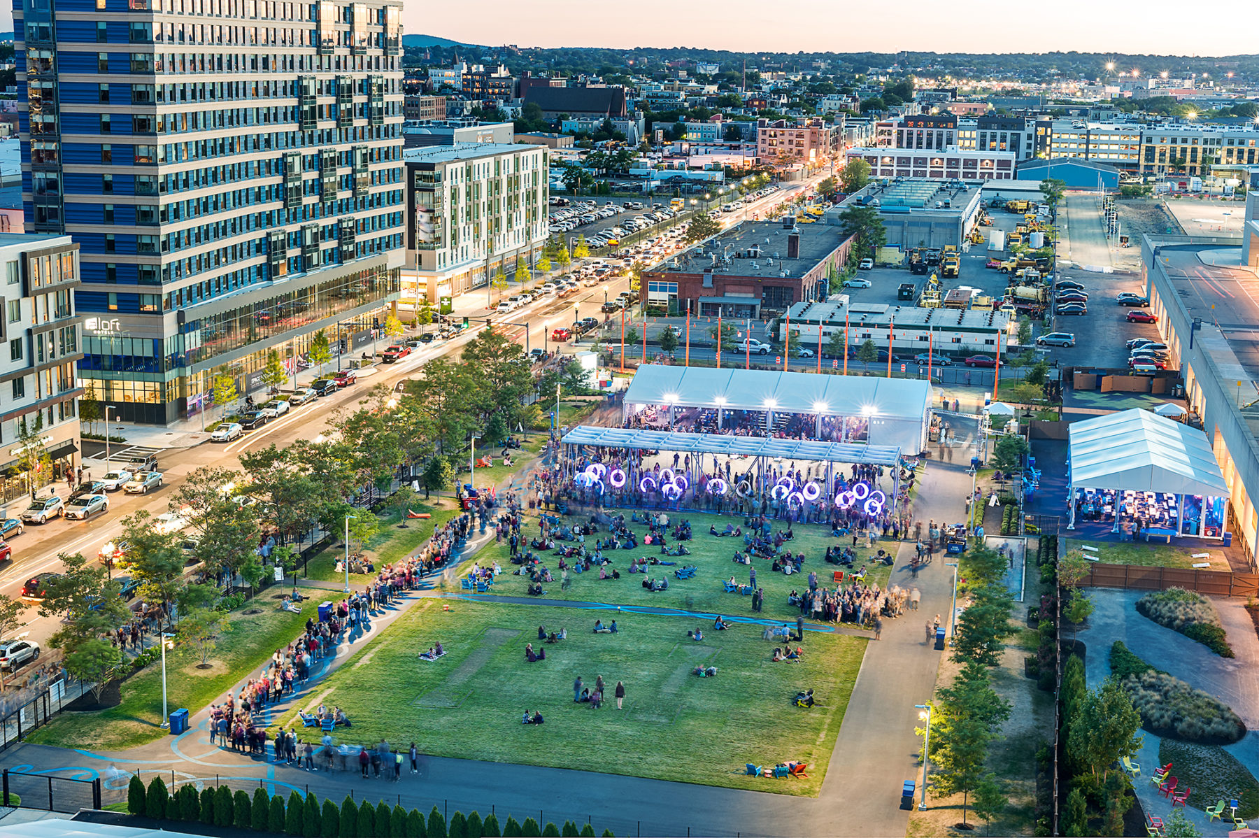 Aerial photo overlooking the built hotel and Lawn on D at dusk. An event is happening on the lawn.