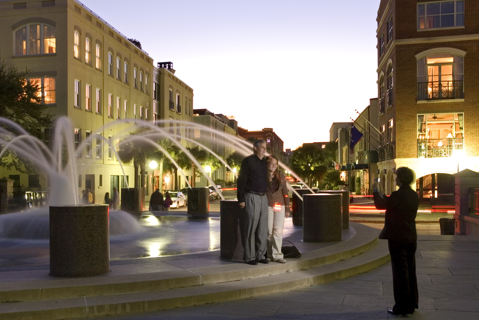 Photo of people posing for a photo at fountain in park