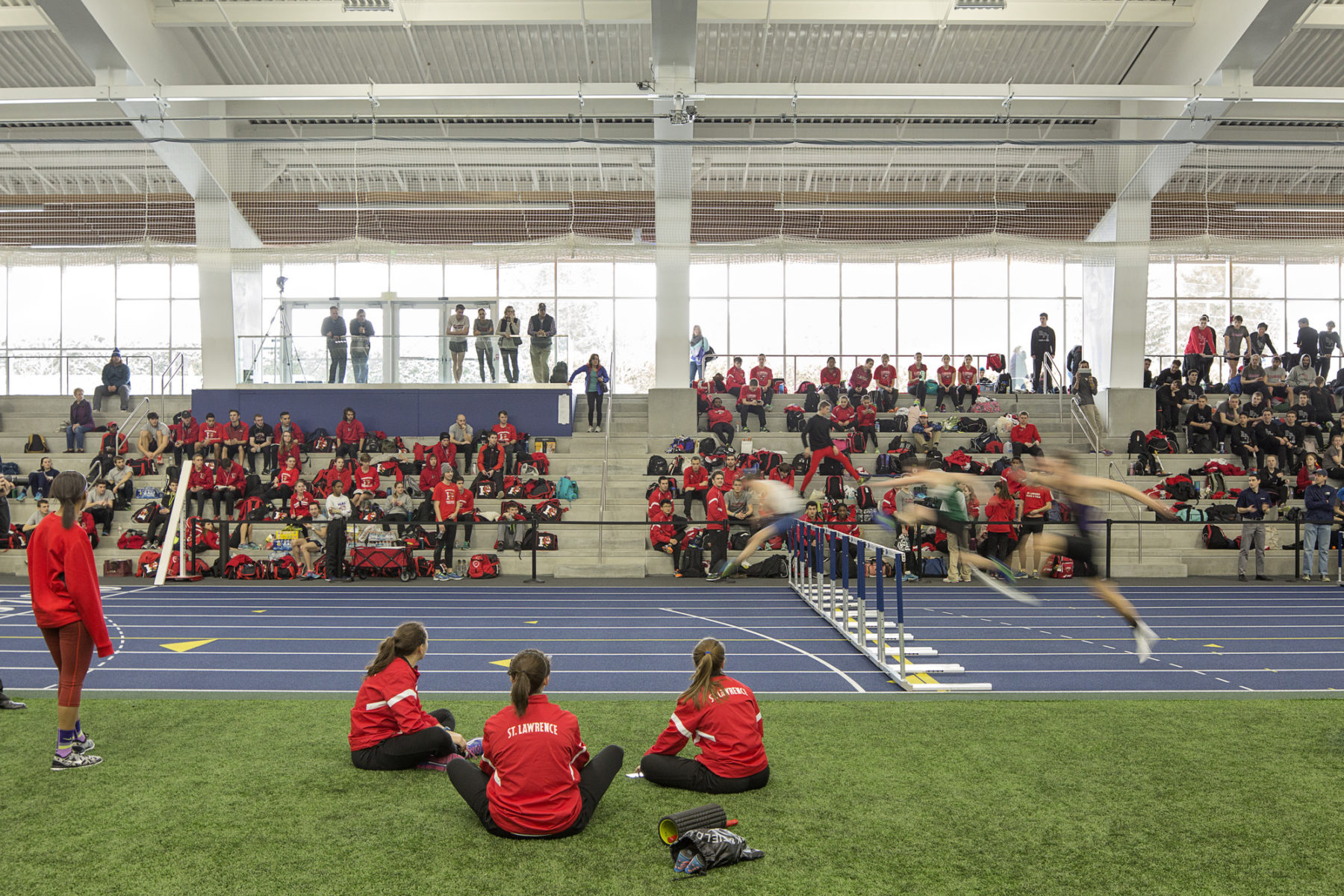 spectators sit by an indoor track