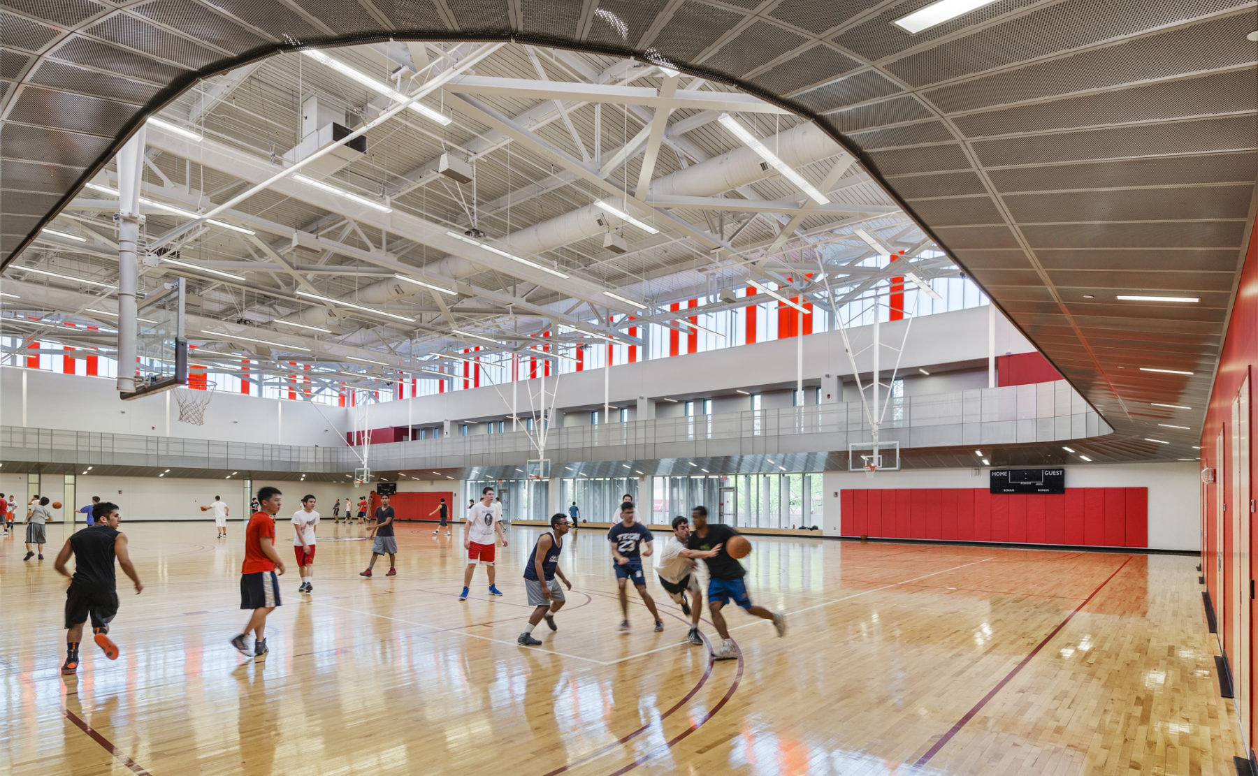 photograph of interior basketball court with people playing basketball