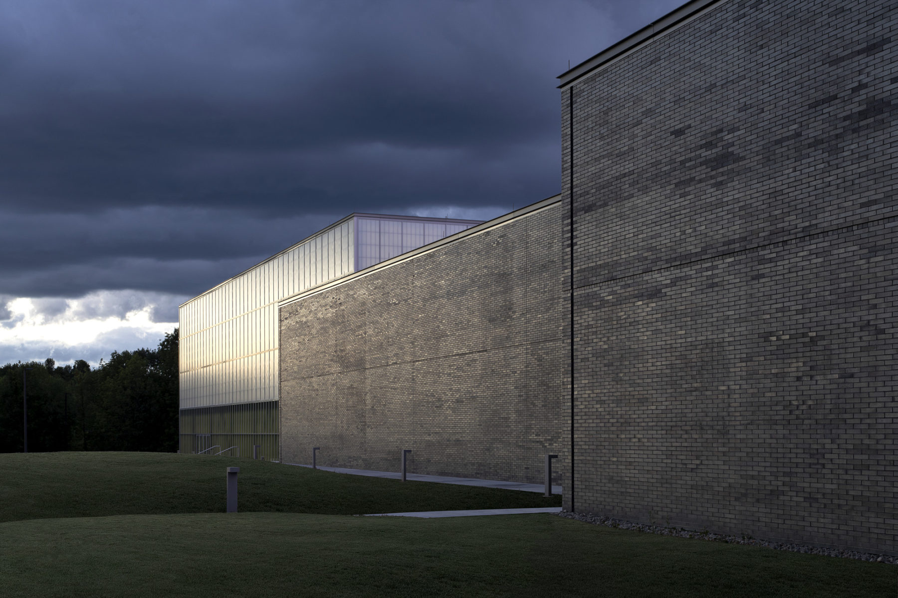 exterior photo of building - volumes of space are expressed in gray brick and curtainwall