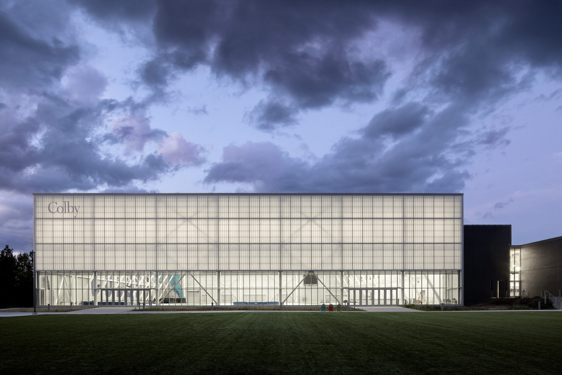 photo of building exterior at night. the interior of the field house glows