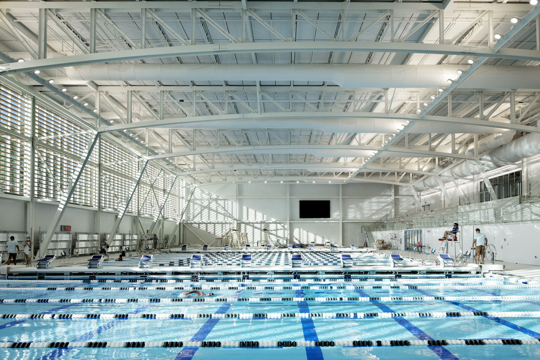 interior photo of natatorium. Light seeps through the windows on the left of the image