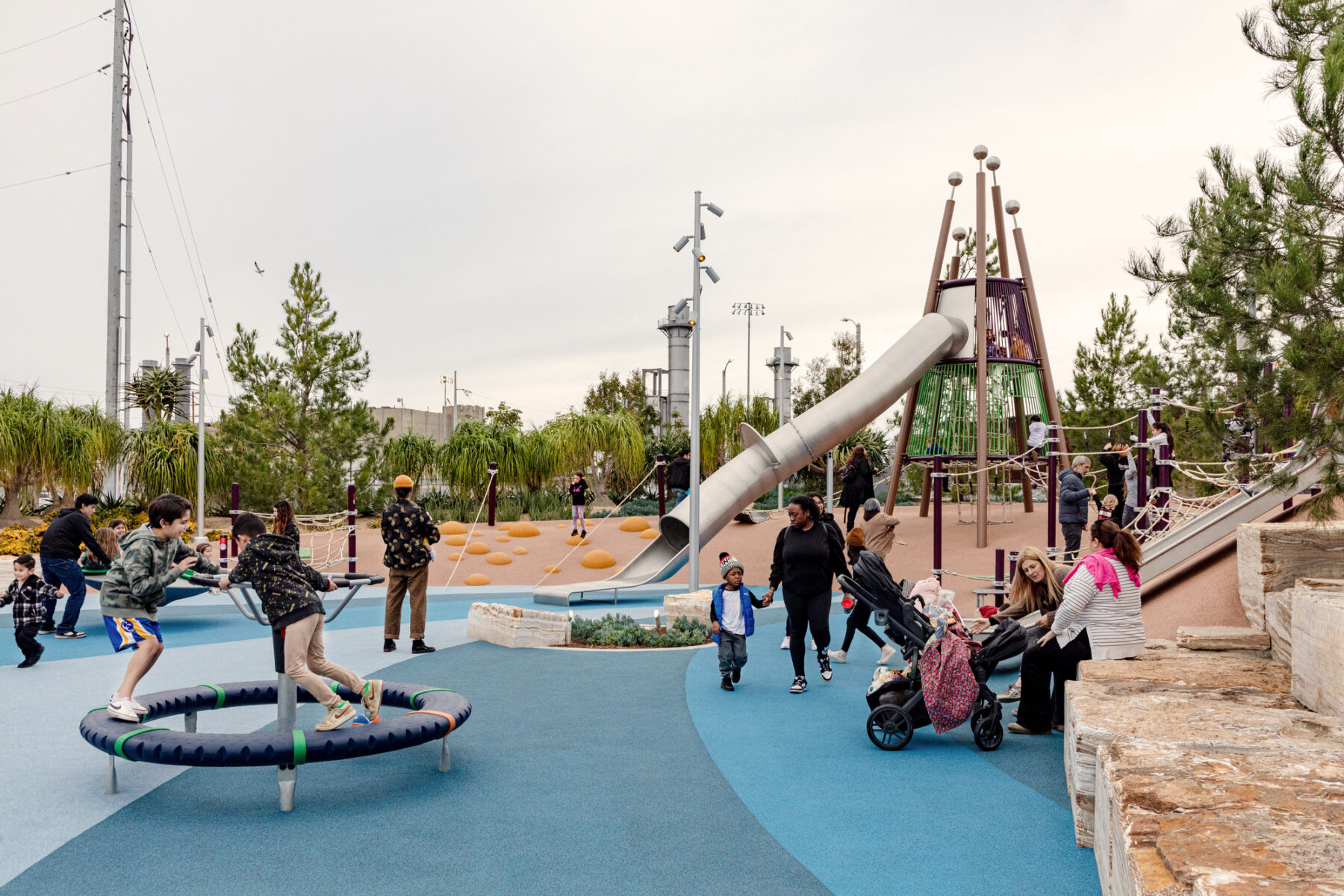 photo of the playground with children and families enjoying the playscape elements