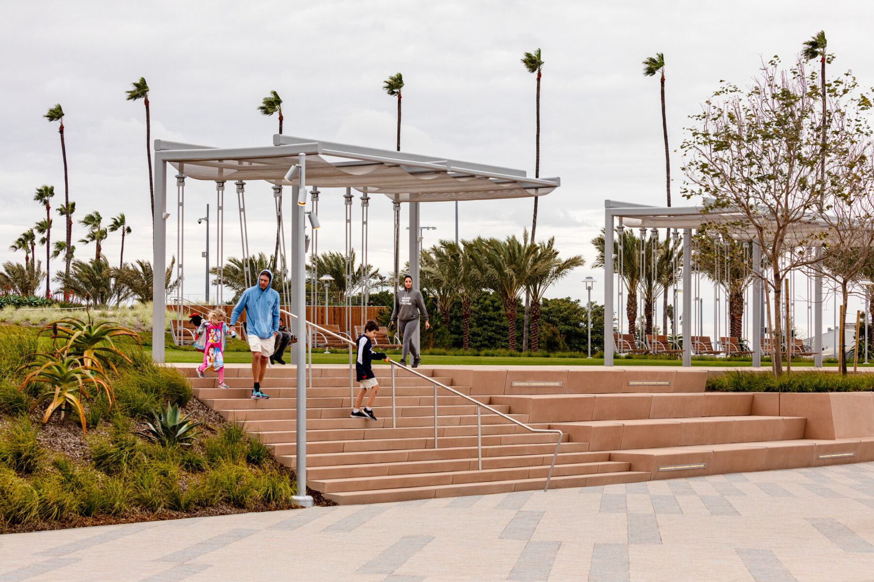 photo looking towards pavilions with stairs and a father with two small children descending