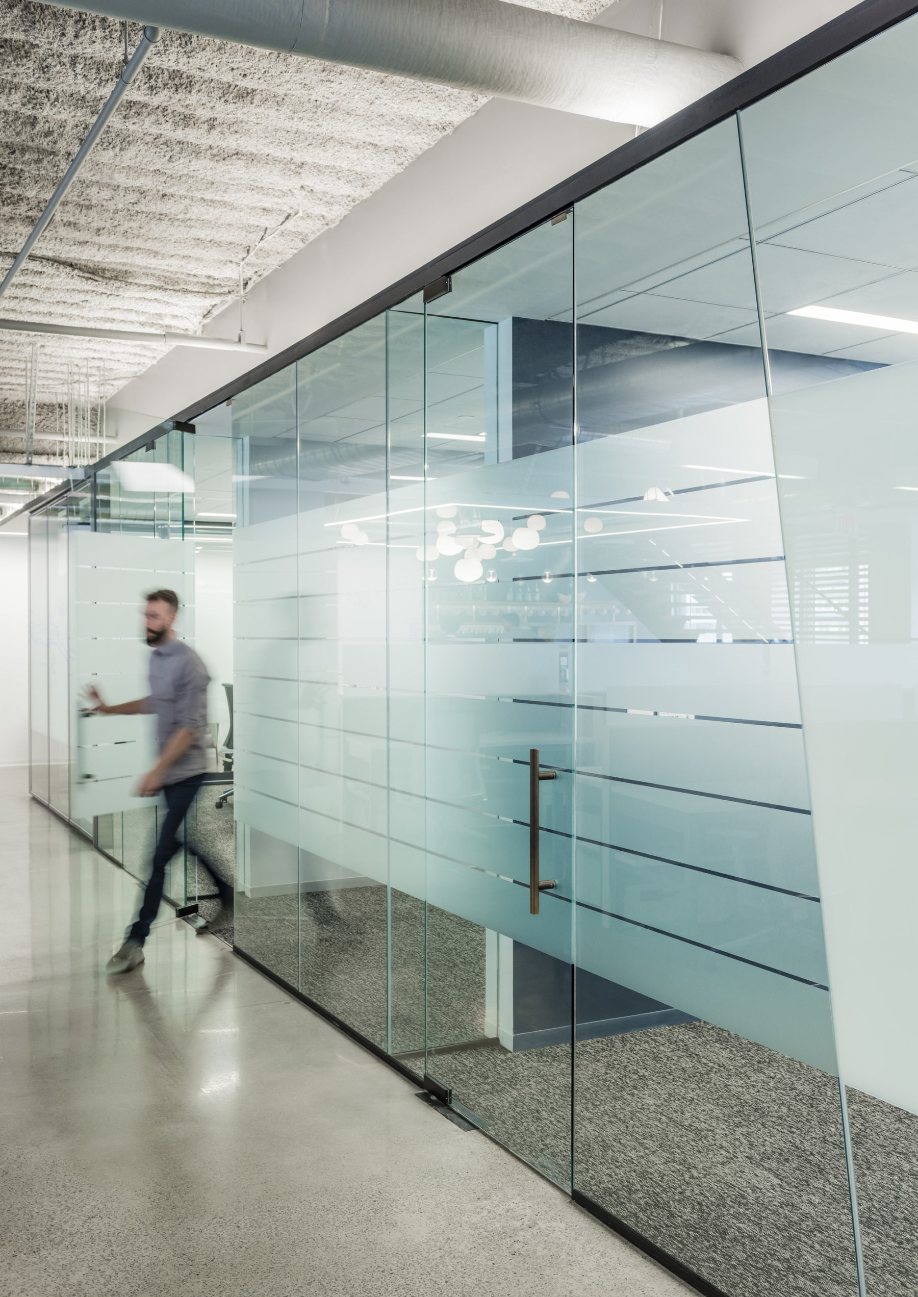 Man leaving the transparent/opaque meeting room.