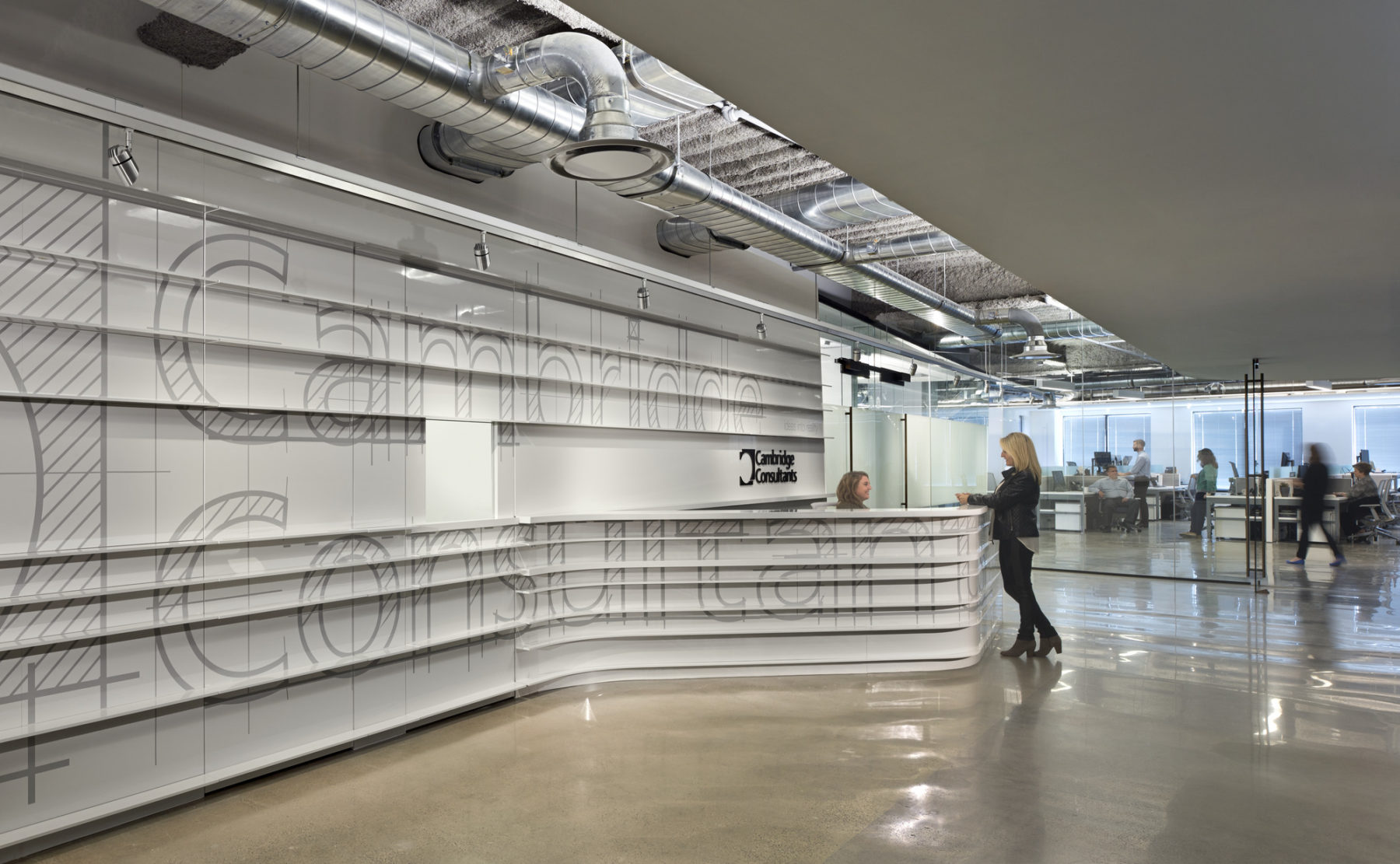 Reception of Cambridge Consultants. White, sleek, clean backdrop to reception station with huge letters saying 