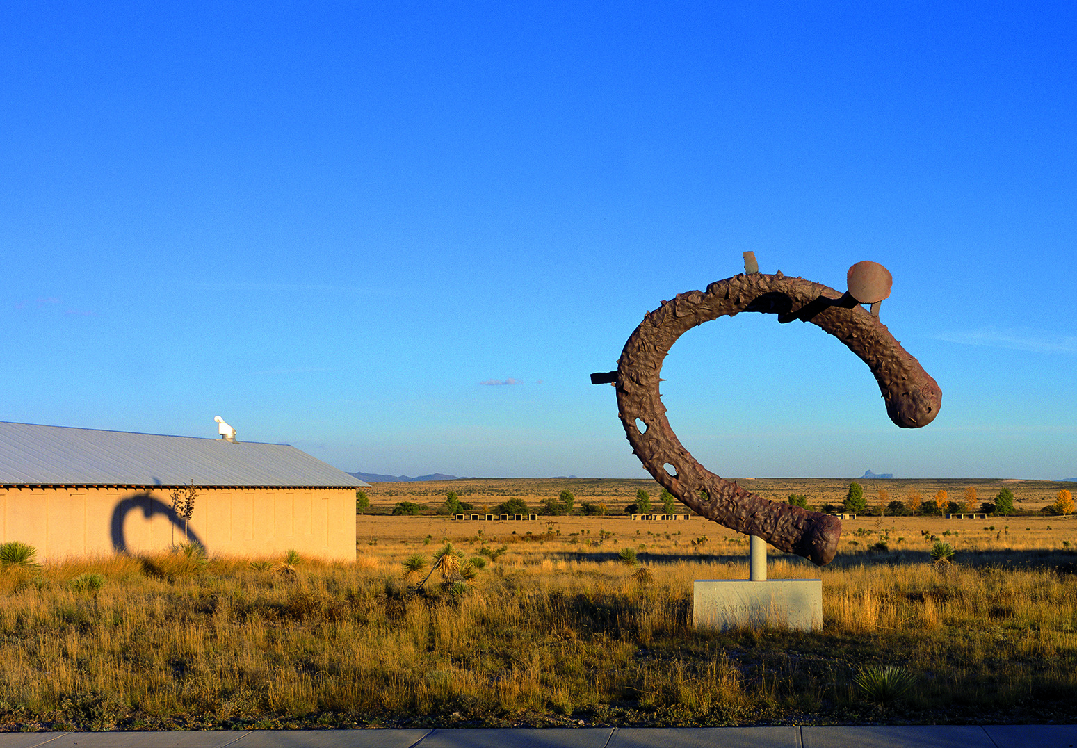 Exterior view with sculpture in the front and side of building towards the back.