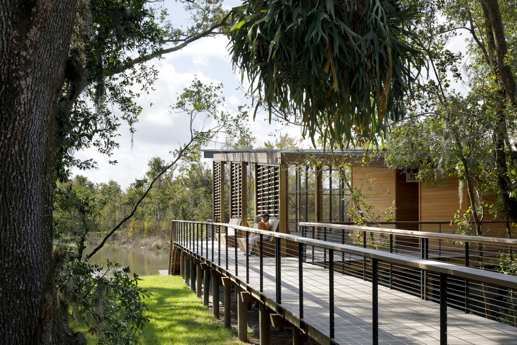 couple sitting on bench, elevated walkway to nature center