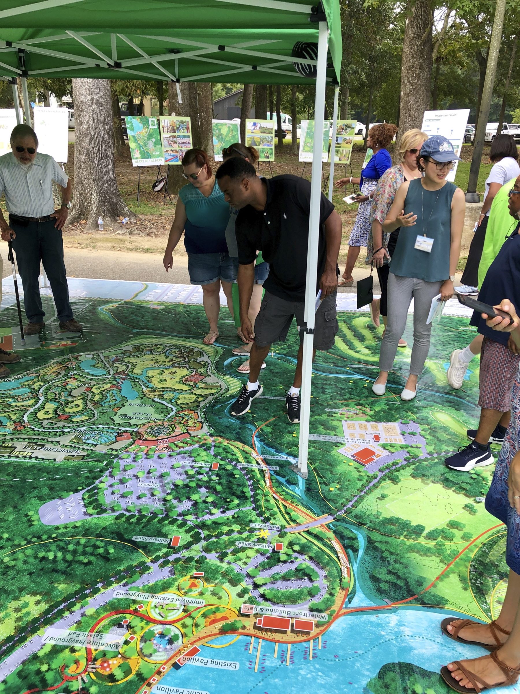 A group of people stand on a map and talk