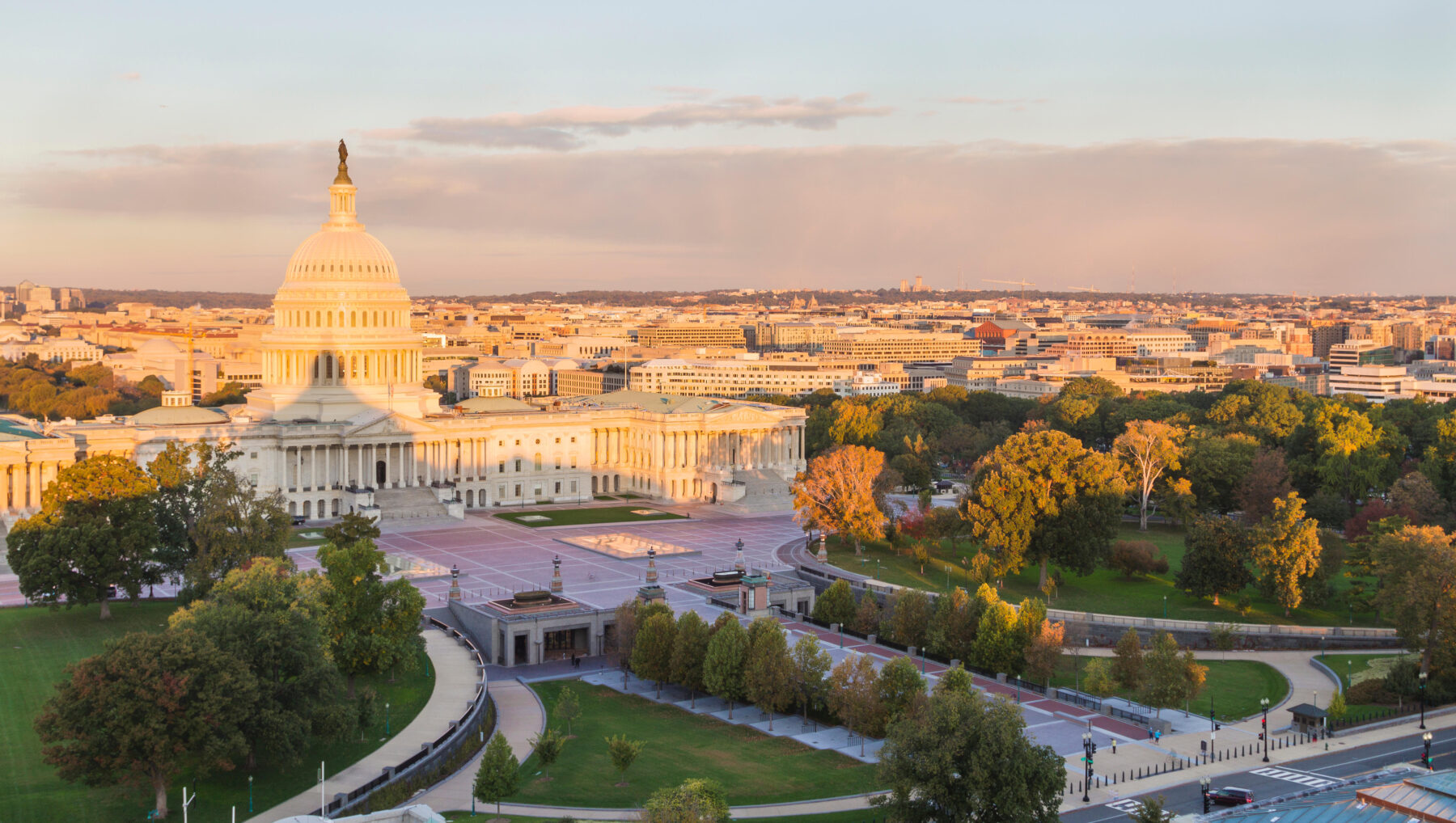 Aerial photo of the sun setting over the U.S. Capitol building and its surrounding landscape