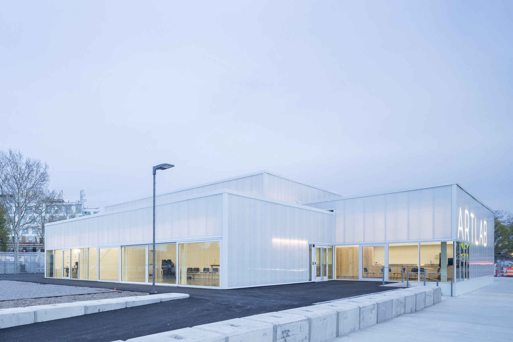 Exterior dusk photo looking into the building's main spaces