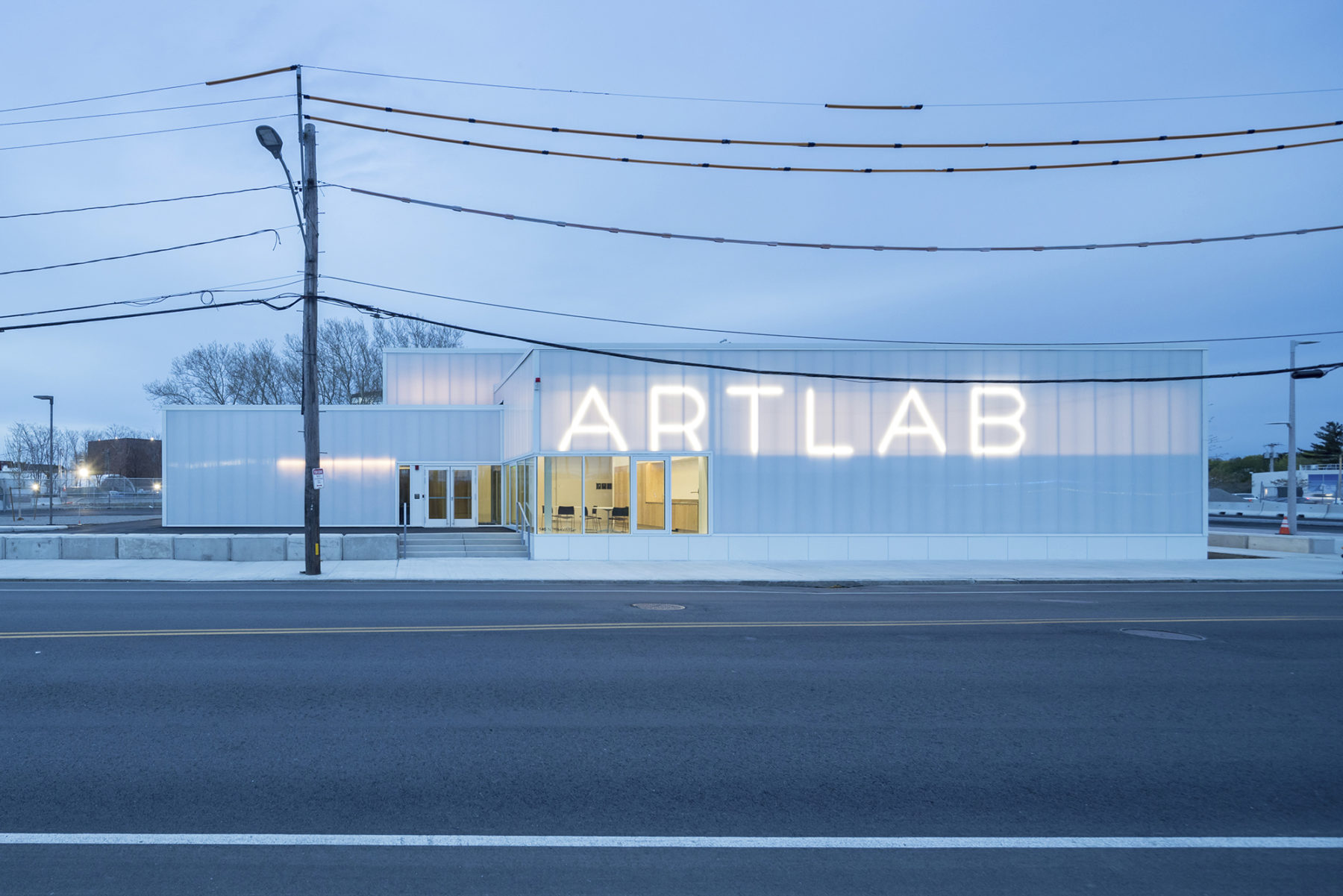 Exterior elevational view of the building at dusk with the lighted sign